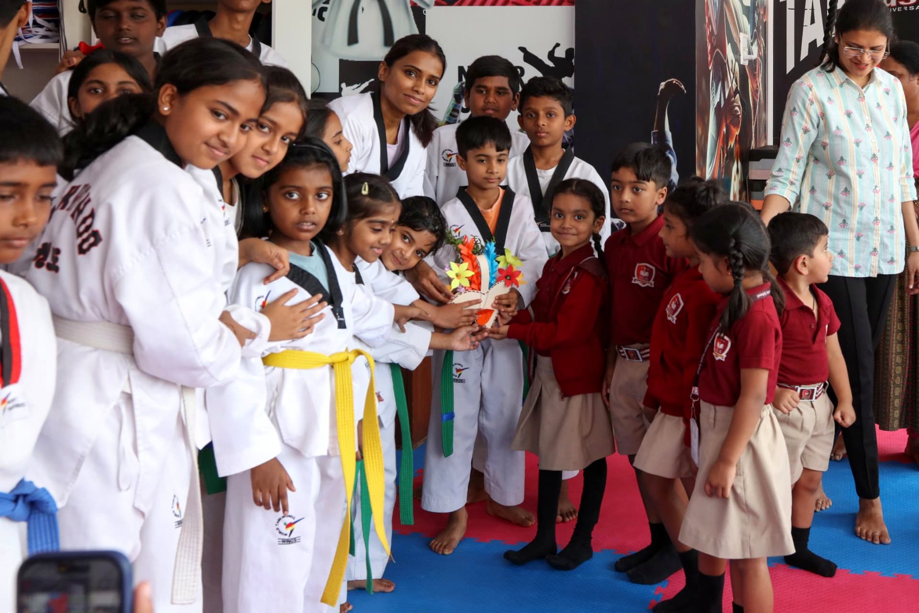 Students greeting guests with a handmade bouquet at the academy