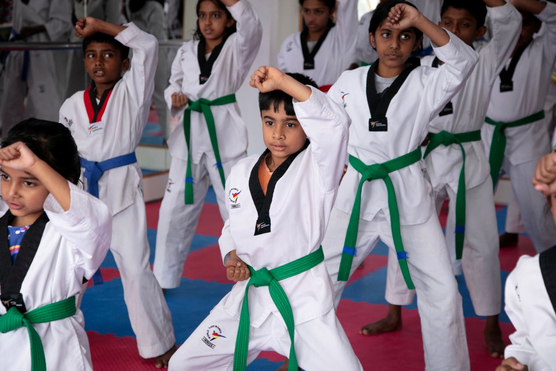 Green belt students holding a blocking stance during class