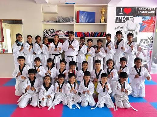 Students at the academy with trophies and murals