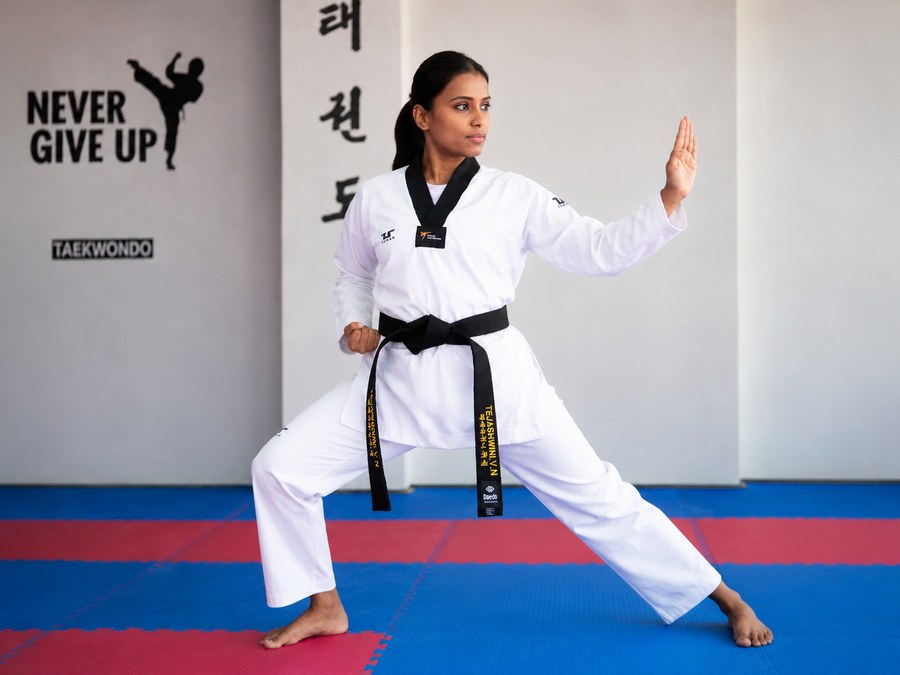 Master Tejashwini VN holding a taekwondo stance in the dojang
