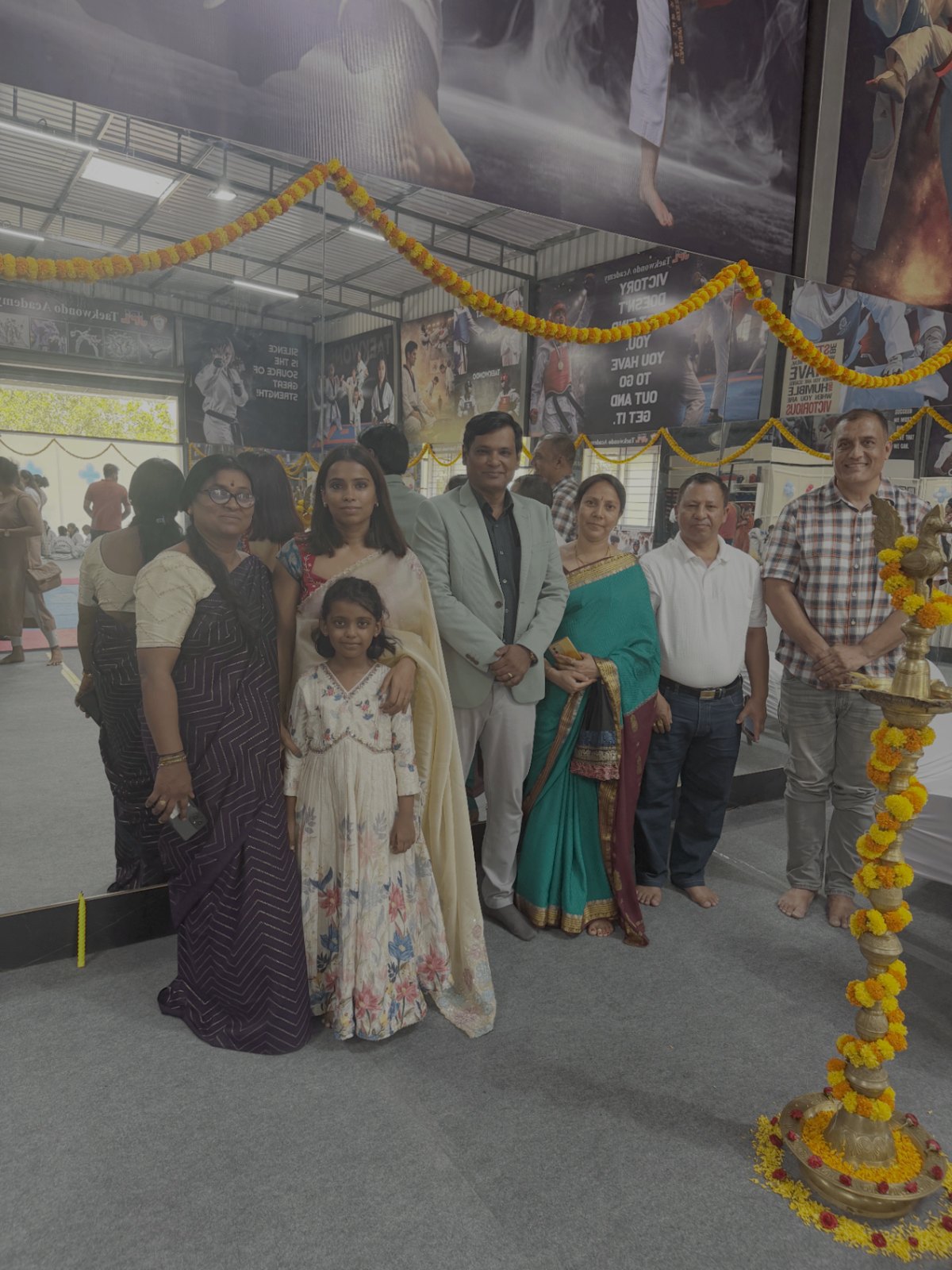 Master Tejashwini VN with family and guests beside the ceremonial lamp